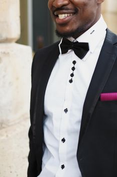 Afro american happy good looking man wearing suit and smiling outdoors. Concept of black businessman.