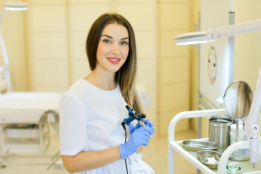 Young permanent makeup artist sitting with microblading device at beauty salon. Concept of cosmetology equipment and cosmetologist.