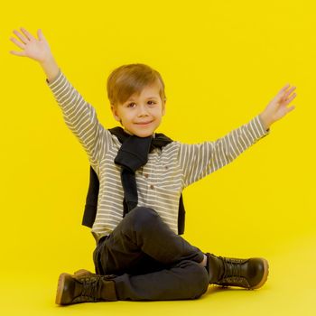 Little boy emotionally waving his hands in the studio . The concept of a happy childhood, family and people. Isolated.
