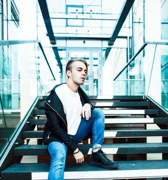 young modern hipster guy at new building university blond fashion handsome boy, lifestyle people concept closeup