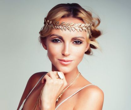 young blond woman dressed like ancient greek godess, gold jewelry close up isolated, summer trends closeup