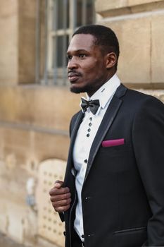 Afro american happy good looking man wearing suit and smiling outdoors. Concept of black businessman.