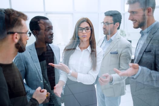 smiling employees discuss new ideas standing in the office.the concept of teamwork