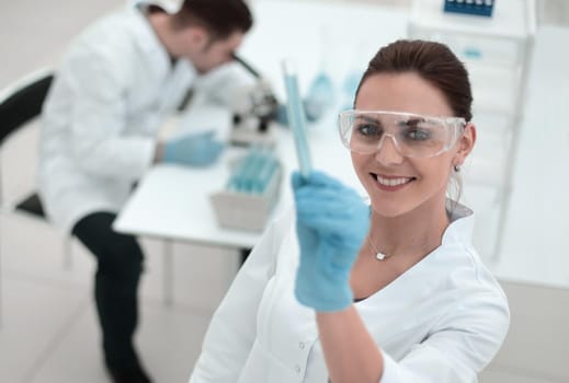 smiling woman scientist looking at the tube with the results of the analysis.photo with copy space