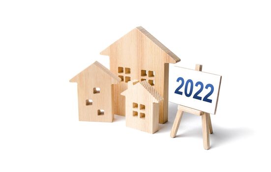 Residential buildings and easel 2022. Concept of real estate market in new year. Housing market predictions, trends and tendencies. Investment plans. Mortgage loan. Economic analysis. Home loans