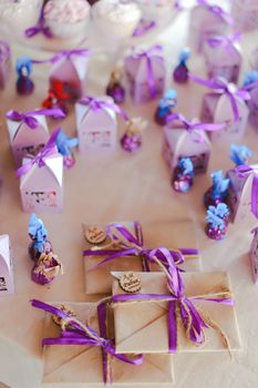 Cute violet decorations for birthday party, sweets and envelopes. Concept of congratulations and decor.