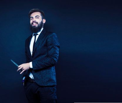 portrait of young bearded hipster guy on gray dark background close up, brutal modern man in suit, lifestyle people concept close up