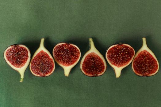 Sliced figs on the background of a green napkin top view.