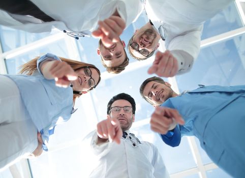 A team of young doctors stands around and points at you with a finger.