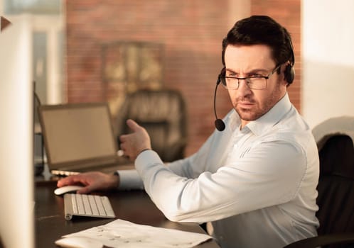 close up.businessman with a headset sitting at his Desk.people and technology