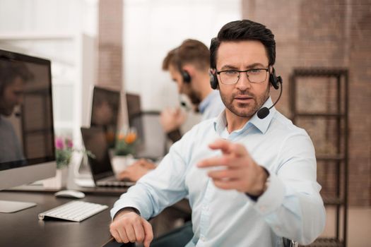 Group of business colleagues with headsets using computers at office desk.business concept
