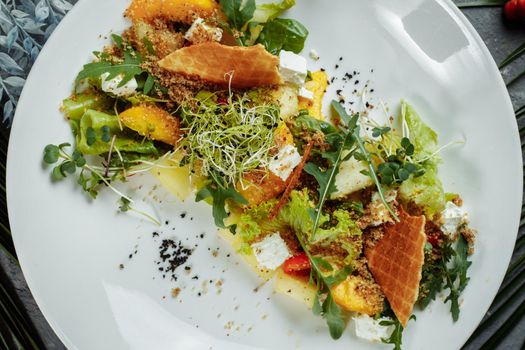 Summer diet salad with leaves of lettuce, watermelon, peach and feta cheese. On a light blue background copy space.