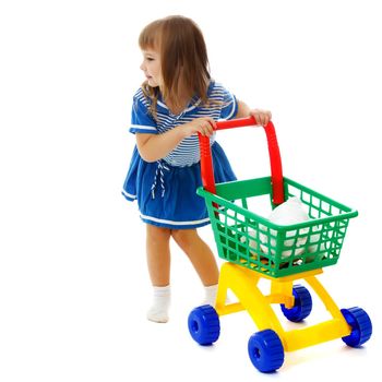 A cute little girl with a cart at the supermarket is shopping. The concept of advertising and selling goods and services. Isolated on white background.