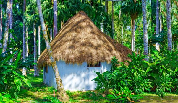 Romantic gazebo in the park with thatched roof. The concept of a family holiday, tourism.