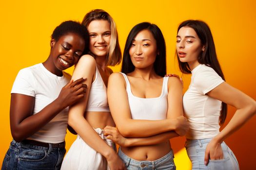 diverse multi nation girls group, teenage friends company cheerful having fun, happy smiling, cute posing on yellow background, lifestyle people concept, african-american, asian and caucasian close up