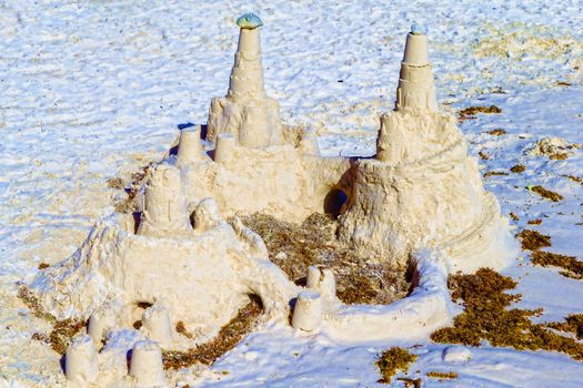 Sand castle on the shores of the warm tropical sea. The concept of a summer family vacation.