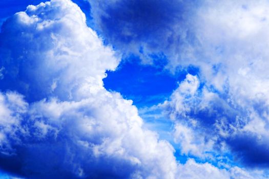 Thick cumulus clouds against a blue sky.