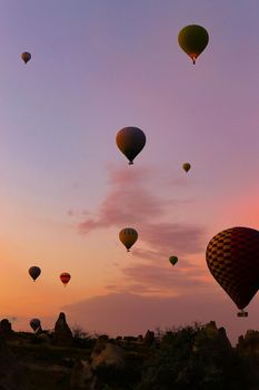 Hot colorful air ballons flying over Cappadocia. Concept of trip to Turkey, turkish vacations.