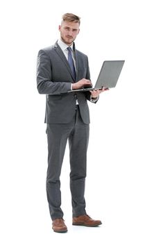 in full growth, a businessman with an open laptop.isolated on white background