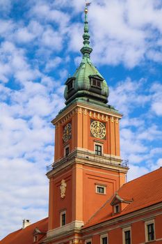 Clock Tower of the Royal Palace in Warsaw, Poland on the background of blue sky with clouds