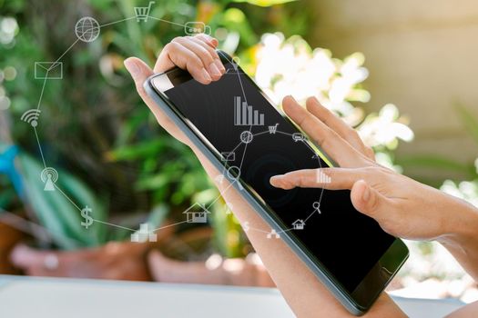 Woman hand holding tablet with blurred social media and technology icons.