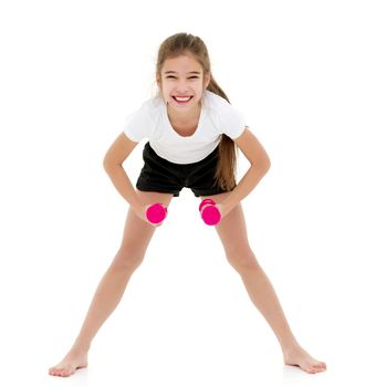 A teenage girl with dumbbells in her arms performs exercises in the fitness club. The concept of sport and a healthy lifestyle of the younger generation. Isolated over white background