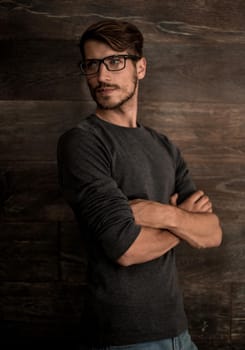 Elegant man in glasses over dark background. Optics style for men. Handsome businessman in spectacles. Male beauty, fashion.