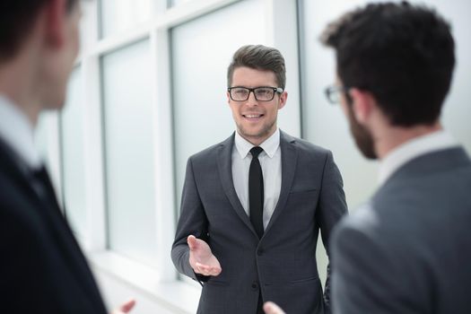 boss talking to employees standing in the office.business concept