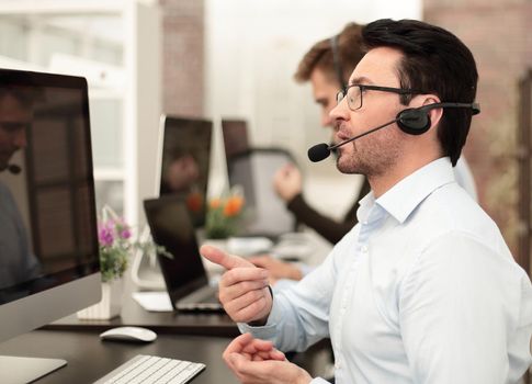 Group of business colleagues with headsets using computers at office desk.business concept
