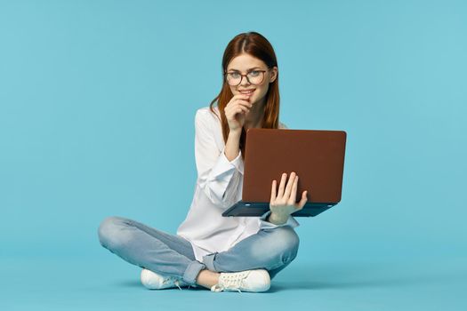 woman with laptop learning internet online education blue background. High quality photo