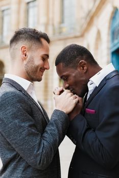 close up portrait of afro american guy kissing caucasian boy hands. Concept of same sex couple, gays and lgbt proposal