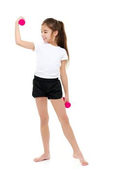 A cute little girl doing exercises with dumbbells. The concept of strength, health and sport. Isolated on white background.