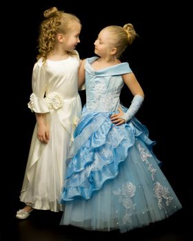 Two cute little girls in full growth, in the studio on a white background. The concept of a happy childhood, Beauty and fashion. Isolated.