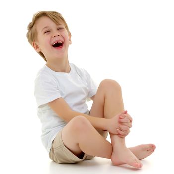 A handsome little boy laughs cheerfully in the studio on a white background. He is dressed in a pure white T-shirt on which you can put any picture or inscription. The concept of children's emotions, advertising. Isolated on white background.