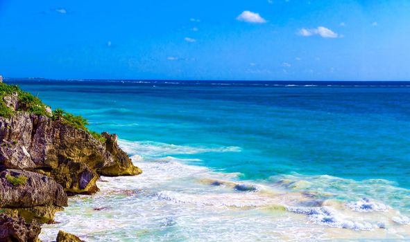 The rocky shore is covered with vegetation on the shore of the paradise blue lagoon of the warm tropical sea.