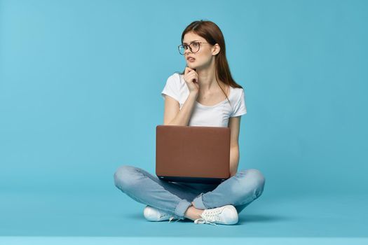 woman with laptop learning internet online education blue background. High quality photo