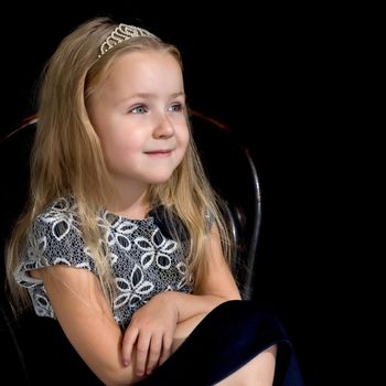 Beautiful little girl on a black background. Studio photography