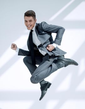 Full length portrait of a happy satisfied man in suitt jumping and looking at camera isolated over white background