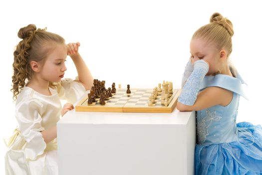 two very reasonable little girls playing chess. Concept of mental development of the child in the family and school. Measurement on a white background.