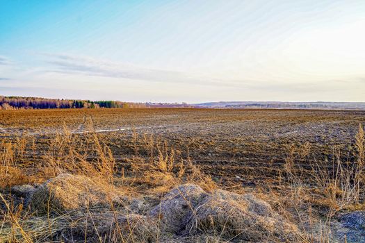 Plowed field in early spring in central Russia. The snow has just come down, the earth is still very soft and friable.