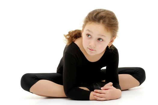 A sweet little gymnast girl performs an acrobatic element on the floor. The concept of sport, healthy lifestyle. Isolated on white background.