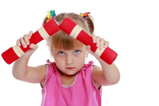 A cute little girl doing exercises with dumbbells. The concept of strength, health and sport. Isolated on white background.