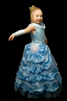 Beautiful little girl in a long, elegant dress. Studio Princess on a black background. Concepts and trendy form for a magazine cover.