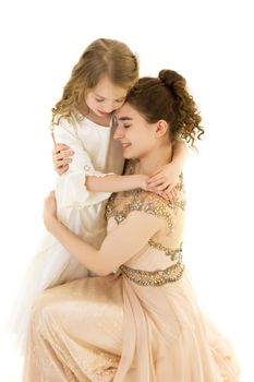 Beautiful young girl hugging her little sister. The concept of a happy childhood, family values. Isolated on white background.