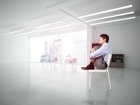 scared businessman sitting on a chair with his hands clasped his knees