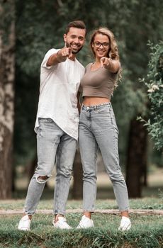 loving couple standing in the Park and pointing at you.photo with copy space