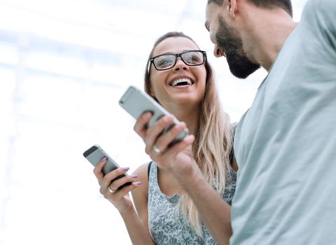 happy young couple with smartphones discussing video files .people and technology