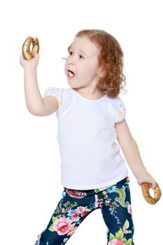 The little girl is eating a bagel. The concept of a healthy baby food. isolated on white background