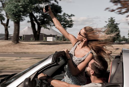 young woman taking a selfie in the car.travel together