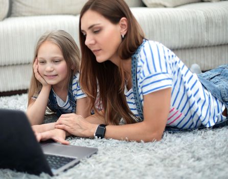 mother and daughter using a laptop in their home.people and technology